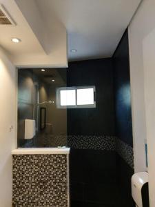 a bathroom with a shower and a sink and a mirror at Pura vida apartments in Quepos