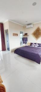 1 dormitorio con 1 cama de color púrpura en una habitación en Summerfield Homestay and Cafe en Pacitan