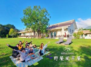 a group of people laying on a blanket in the grass at 台東鹿野森活 訂房後來電確認 in Ruiyuan