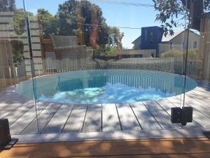 uma grande piscina com um recinto de vidro em Jujube em Dromana