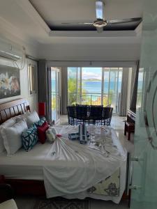 
a room with a table, chairs, and a large window at Treasure Island Retreat in Anse Kerlan
