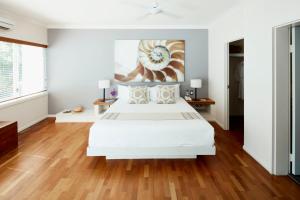 a bedroom with a large bed and a large window at Alamanda Palm Cove by Lancemore in Palm Cove