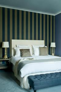 1 cama blanca grande con banco azul en una habitación en Hôtel Particulier - La Chamoiserie, en Niort