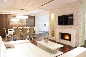 un salon avec cheminée et une salle à manger dans l'établissement Villa Maelynn Opatija with Heated Pool and Sea View, à Rubeši