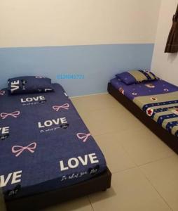 two twin beds in a room with hearts on them at Bishops Cap at Cameron Highlands in Brinchang