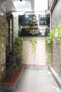 HAPPY GUEST HOUSE في هاي فونج: علامة تقرأ الترحيب بالموسيقى السعيدة على جدار من الطوب