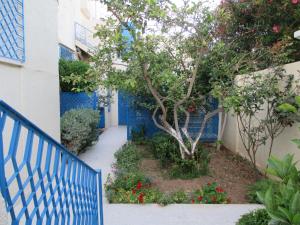 a blue fence and a tree in front of a building at Villa Kenza in Nabeul