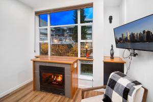 a living room with a fireplace and a tv at Modern Studio at Blackcomb base in Whistler