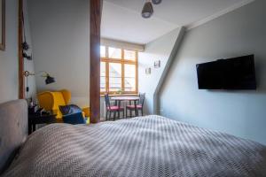 1 dormitorio con 1 cama y 1 mesa con sillas en Langer House apartment in Old Riga en Riga
