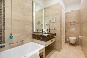 a bathroom with a tub and a sink and a toilet at Hotel an der Oper in Munich