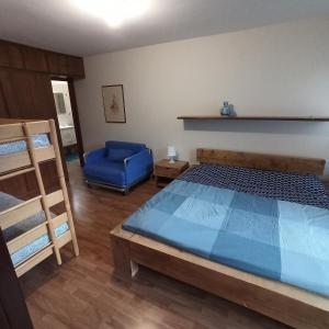 a bedroom with a bed and a blue chair at Alpestre Trifolium Appartamento Trilo Cervinia CIR 0427 in Breuil-Cervinia