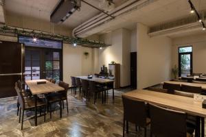 un comedor con mesas, sillas y ventanas en Hotel Brown - Chihkan Branch, en Tainan