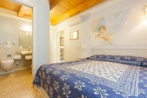 a bedroom with a blue and white bed and a bathroom at Talamo Rooms in San Martino Buon Albergo +28 photos