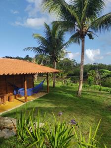 a resort with a hammock in a yard with palm trees at Pousada Rancho Sêmani in Itacaré