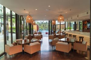 InterContinental Dhaka, an IHG Hotel في داكا: مطعم بطاولات وكراسي ونوافذ