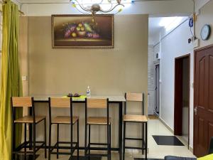 a kitchen with a table with chairs and a painting of fruit at Champs De Mars Apartment in Port Louis