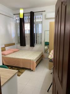ein kleines Schlafzimmer mit 2 Betten und einem Fenster in der Unterkunft Champs De Mars Apartment in Port Louis