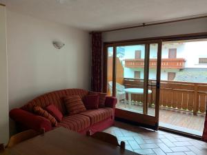 a living room with a couch and a balcony at Monolocale Campodolcino in Campodolcino