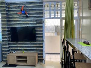 a living room with a tv on a brick wall at Champs De Mars Apartment in Port Louis