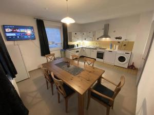 a kitchen and dining room with a wooden table and chairs at Ferienwohnung Zusmarshausen in Zusmarshausen