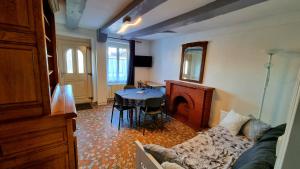 uma sala de estar com um sofá e uma mesa e uma sala de jantar em Le 3 Rue de Fontenay em Marmagne