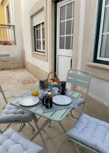 a table with two chairs and plates of food on it at Maré Baixa in Sines