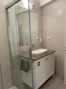 a bathroom with a sink and a glass shower at Maré Baixa in Sines