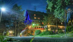 a large house with lights on it at night at Penzion Sykovec in Tři Studně