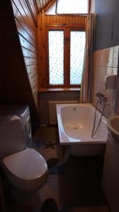 Excelsior Guesthouse في يورمالا: حمام مع مرحاض وحوض استحمام ومغسلة