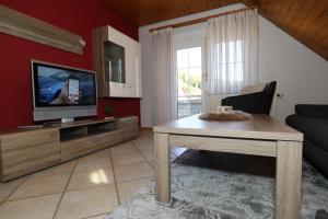 a living room with a television and a table at Ferienwohnung im Steinachtal in Nagold