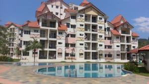 een groot appartementencomplex met een zwembad ervoor bij Harnizam Muslim Homestay in Tambun