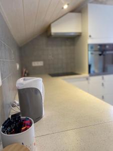 a kitchen counter with a container of wine bottles at Au cœur des stations de ski, 10 min de la suisse in Damprichard