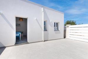 a white house with a white fence and a patio at Margló in Avola