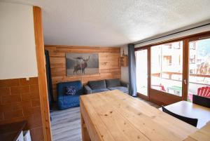 a living room with a table and a couch at L'Enchalpe, Grand et lumineux studio avec coin montagne 5 personnes, 60m des pistes, PISCINE COUVERTE, WIFI, grand balcon expo EST, DRAPS NON COMPRIS in Saint-Jean-dʼAulps