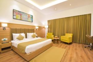 a hotel room with a bed and a chair at SureStay Heritage Walk By Best Western in Amritsar