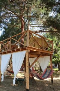 a tree house with two hammocks under a tree at Gongis Studios in Agios Georgios