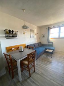 ein Wohnzimmer mit einem blauen Sofa und einem Tisch in der Unterkunft Appartement aux pieds des pistes ! in Les Angles