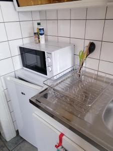 uma cozinha com um suporte para pratos num micro-ondas em Les Locations de Stéphanie ,Gite Le Verger em Sondernach