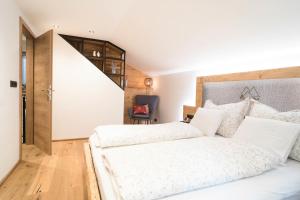 1 dormitorio con 2 camas blancas y escalera en Ferienhaus Leite Häusl en Sankt Jodok am Brenner