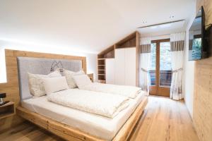 een slaapkamer met een groot bed met een houten hoofdeinde bij Ferienhaus Leite Häusl in Sankt Jodok am Brenner