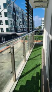 a balcony with green grass on a building at Aeropod KK Corner Unit Near City and Airport 4 pax Free Parking in Kota Kinabalu