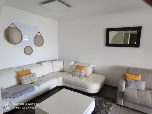 a living room with a white couch and a mirror at villa Areca in Saint-Joseph