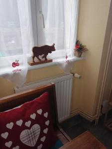 a cat statue on a window sill in a room at Les Locations de Stéphanie ,Gite Le Verger in Sondernach
