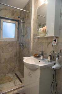 a bathroom with a sink and a shower at CIRIĆ APARTMANI in Vrnjačka Banja