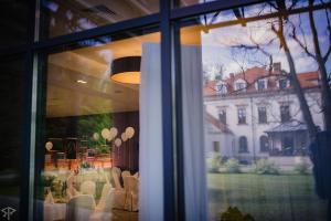 Polanka Conference Center في كروسنو: نافذة مطعم مع طاولة وكراسي