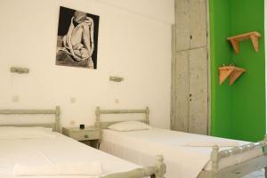 two beds in a room with a green wall at Gongis Studios in Agios Georgios