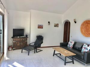 - un salon avec un canapé et une chaise dans l'établissement Casa Olgita, à Playa Blanca
