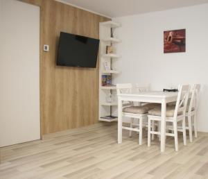 ein weißes Esszimmer mit einem weißen Tisch und Stühlen in der Unterkunft Apartment BIANCA in Braşov