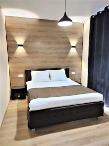 a bedroom with a large bed with a wooden wall at ROCAS Hotel in Orhei