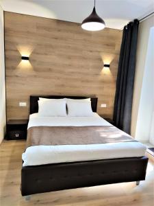 a bedroom with a large bed with a wooden wall at ROCAS Hotel in Orhei